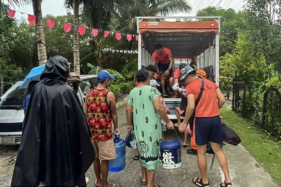 Membros da guarda costeira auxiliando na evacuação de moradores da cidade de Guiuan, província de Samar Oriental, região central das Filipinas, antes da chegada do tufão Kalmaegi.