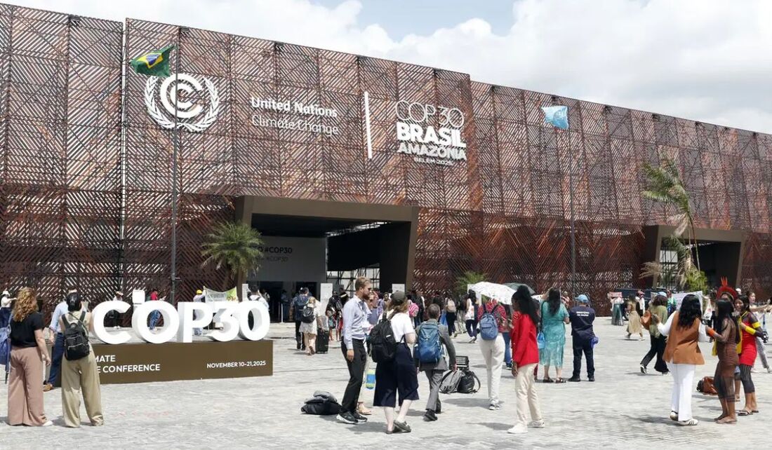 Pessoas em frente a fachada do pavilhão, na COP30