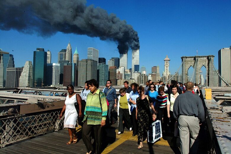 Pedestres caminham pela Ponte do Brooklyn para longe das torres em chamas do World Trade Center antes de seu colapso - Foto: Henny Ray Abrams/AFP/arquivo