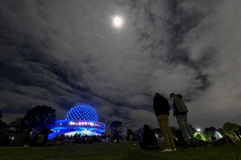 Pessoas olham para o céu durante eclipse total da lua em Buenos Aires, Argentina (Foto: Luis Robayo/AFP)