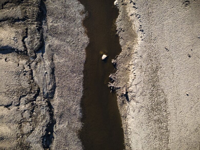Uma vista aérea mostra os restos da vila submersa de Gary Qasruka, que foi abandonada em 1985 e parcialmente ressurgiu recentemente após uma grande queda no nível da água da represa de Dohuk devido à seca, na cidade de Dohuk, no norte do Iraque, na região autônoma curda em 28 de agosto de 2022. Imagem - Lionel Bonaventure / AFP