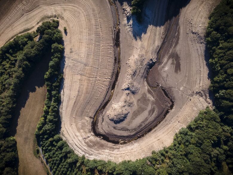 Uma vista aérea mostra os restos da vila submersa de Gary Qasruka, que foi abandonada em 1985 e parcialmente ressurgiu recentemente após uma grande queda no nível da água da represa de Dohuk devido à seca, na cidade de Dohuk, no norte do Iraque, na região autônoma curda em 28 de agosto de 2022. Imagem - Lionel Bonaventure / AFP