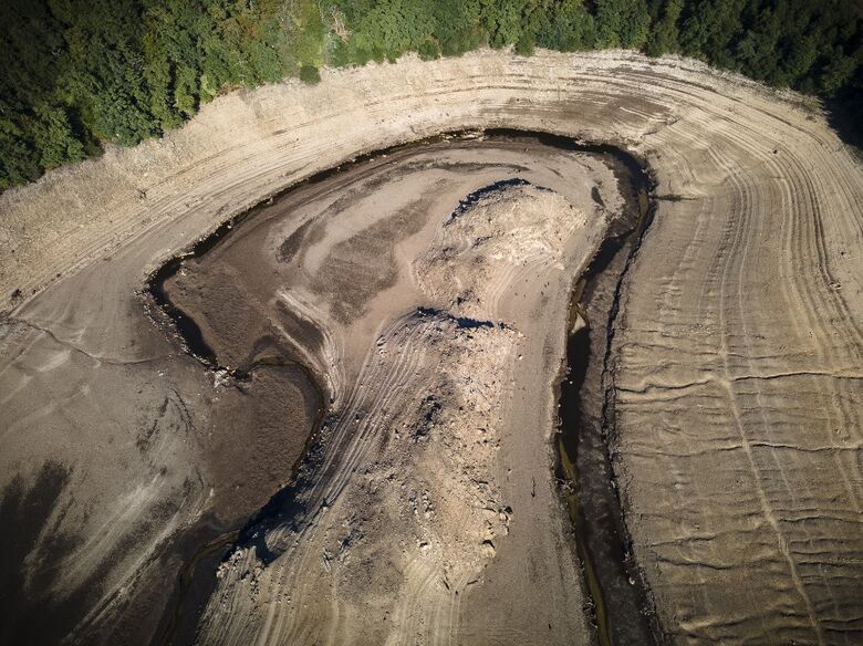 Uma vista aérea mostra os restos da vila submersa de Gary Qasruka, que foi abandonada em 1985 e parcialmente ressurgiu recentemente após uma grande queda no nível da água da represa de Dohuk devido à seca, na cidade de Dohuk, no norte do Iraque, na região autônoma curda em 28 de agosto de 2022. Imagem - Lionel Bonaventure / AFP
