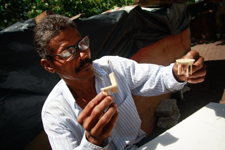 Wellington Pereira faz porta-retratos e casinhas com palitos de picolé e cola branca para vender (Foto: Melissa Fernandes/Folha de Pernambuco)