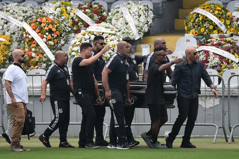 Caixão com corpo de Pelé carregado por seu filho Edinho, o ex-jogador Zé Roberto e seguranças do Santos. Foto: CARL DE SOUZA / AFP