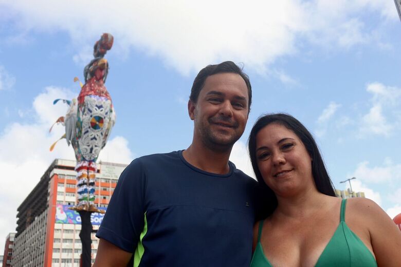 Casal de turistas do Paraná Leandro Jacik e Iara Dutra diante do Galo Gigante 2024 - Foto: Júnior Soares/Folha de Pernambuco