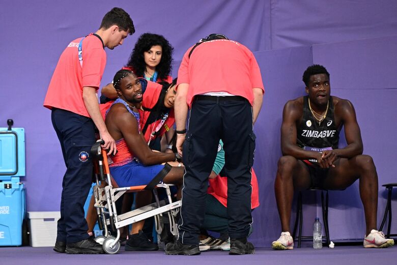 Noah Lyles foi colocado numa cadeira de rodas após a corrida. Foto: KIRILL KUDRYAVTSEV/ AFP