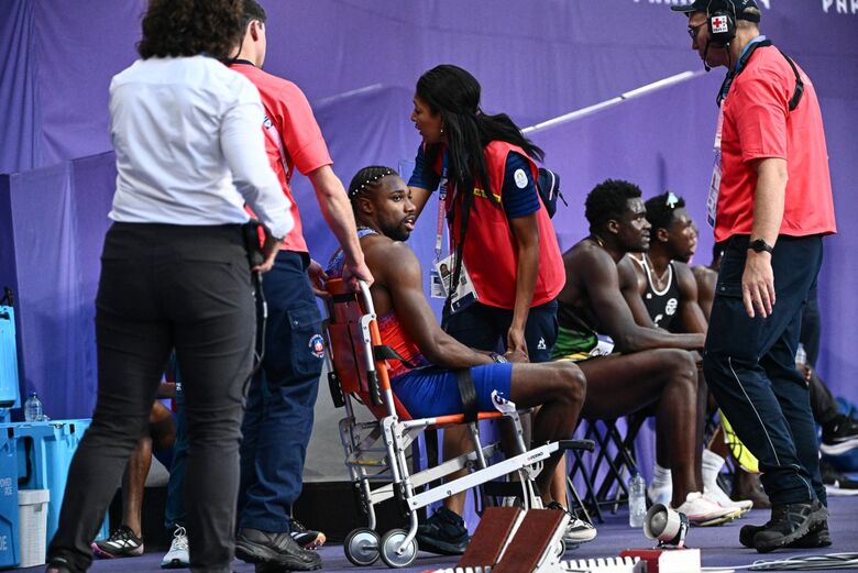 Noah Lyles foi colocado numa cadeira de rodas após a corrida. Foto: JEWEL SAMAD/ AFP