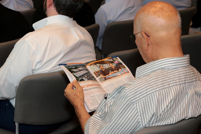 Convidado confere a revista no intervalo do evento