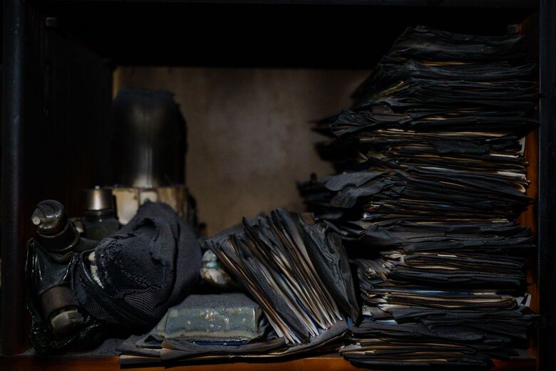 Pertences carbonizados de Kim Seung-weon são vistos nos restos queimados de sua casa, dois dias depois de um incêndio florestal ter varrido sua aldeia, em Andong | Foto: ANTHONY WALLACE / AFP