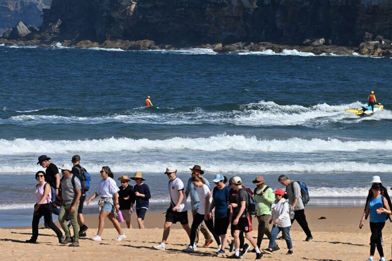 Banhistas e surfistas tiveram que deixar o mar de Sidney, na Austrália, após autoridades fecharem a praia por conta do ataque de tubarão que matou um homem. - Foto: Saeed Khan/AFP