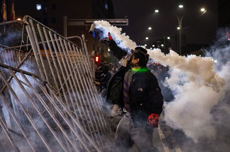 Confrontos entre manifestantes e polícia durante protestos contra o governo do Peru. - Foto: Ernesto Benavides/AFP