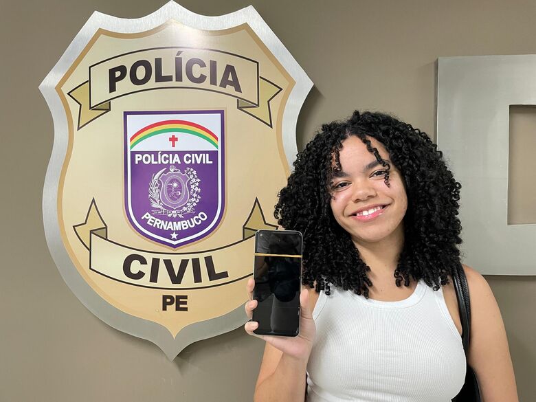 Dona de celular perdido recebe o aparelho durante mutirão no Auditório da Sede Operacional da Polícia Civil de Pernambuco. Divulgação/PCPE