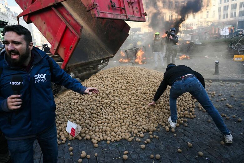 Manifestantes pegam batatas perto do Parlamento Europeu durante um protesto de agricultores contra as reformas da Política Agrícola Comum (PAC) e acordos comerciais como o Mercosul. | Foto: AFP