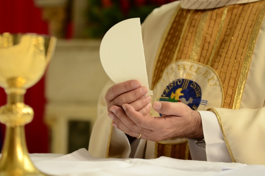Sacerdote com a hóstia, pão sem fermento que, no catolicismo, representa o corpo de Cristo
