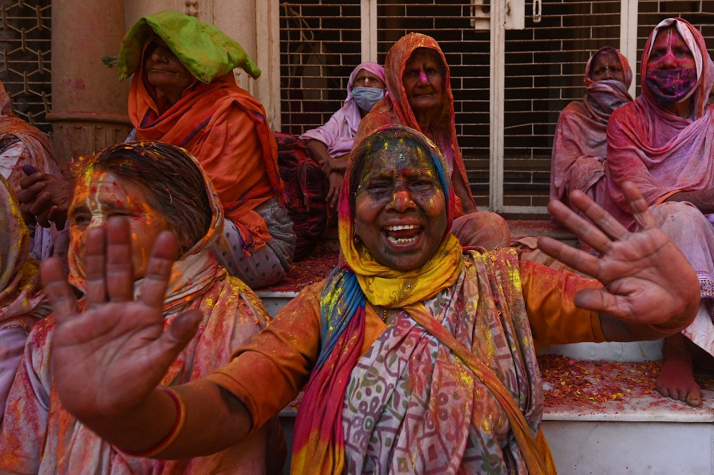 Viúvas manchadas com Gulal (pó colorido) dançam enquanto participam das celebrações do Holi, o festival de cores da primavera hindu, em um templo em Vrindavan em 15 de março de 2022