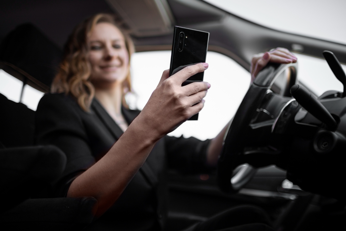 Mulher no carro com smartphone