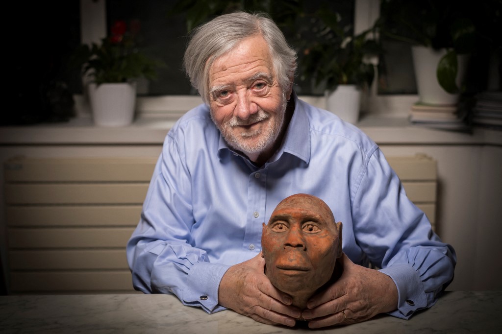 Fotografia de arquivo, tirada em 2 de dezembro de 2016, mostra o paleontólogo francês Yves Coppens posando em sua casa em Paris, segurando um modelo de cabeça de Lucy, uma fêmea de Australopithecus