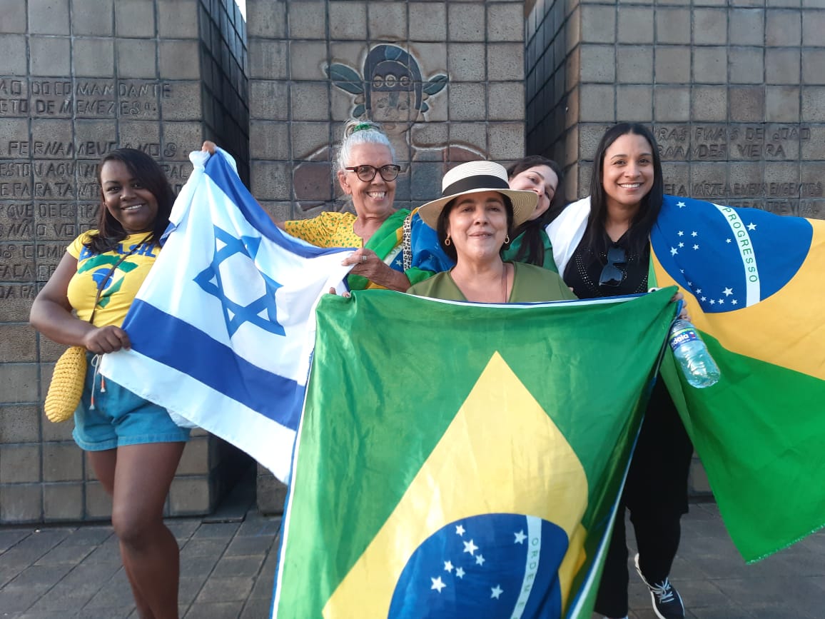 De chapéu, segurando a bandeira do Brasil, Diva Carvalho participa da manifestação pró Bolsonaro na BR - 232 em frente ao Comando Militar do Nordeste