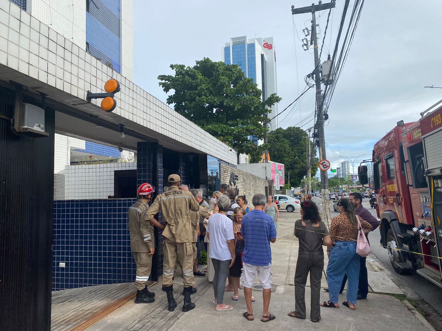 Bombeiros e moradores em frente ao prédio