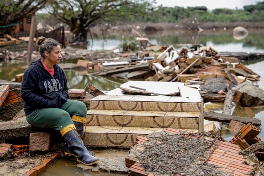 Daiane Azevedo Cabral em frente ao que sobrou da sua casa destruída na Ilha de Pintada 