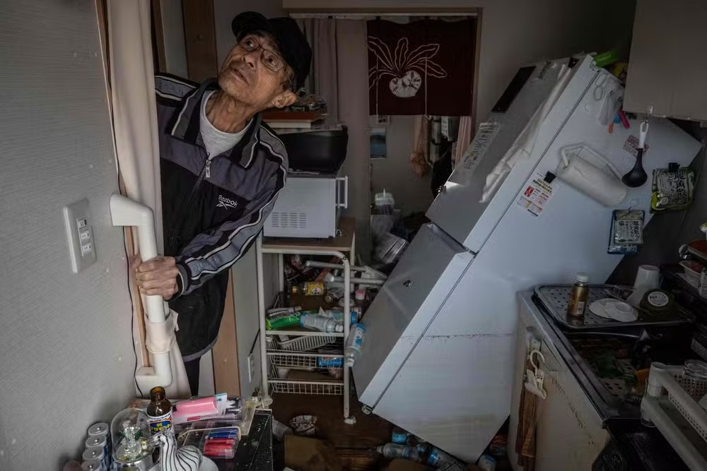 Morador confere os estragos da chuva em sua casa provisória, onde vivia desde o terremoto de 1º de janeiro deste ano 