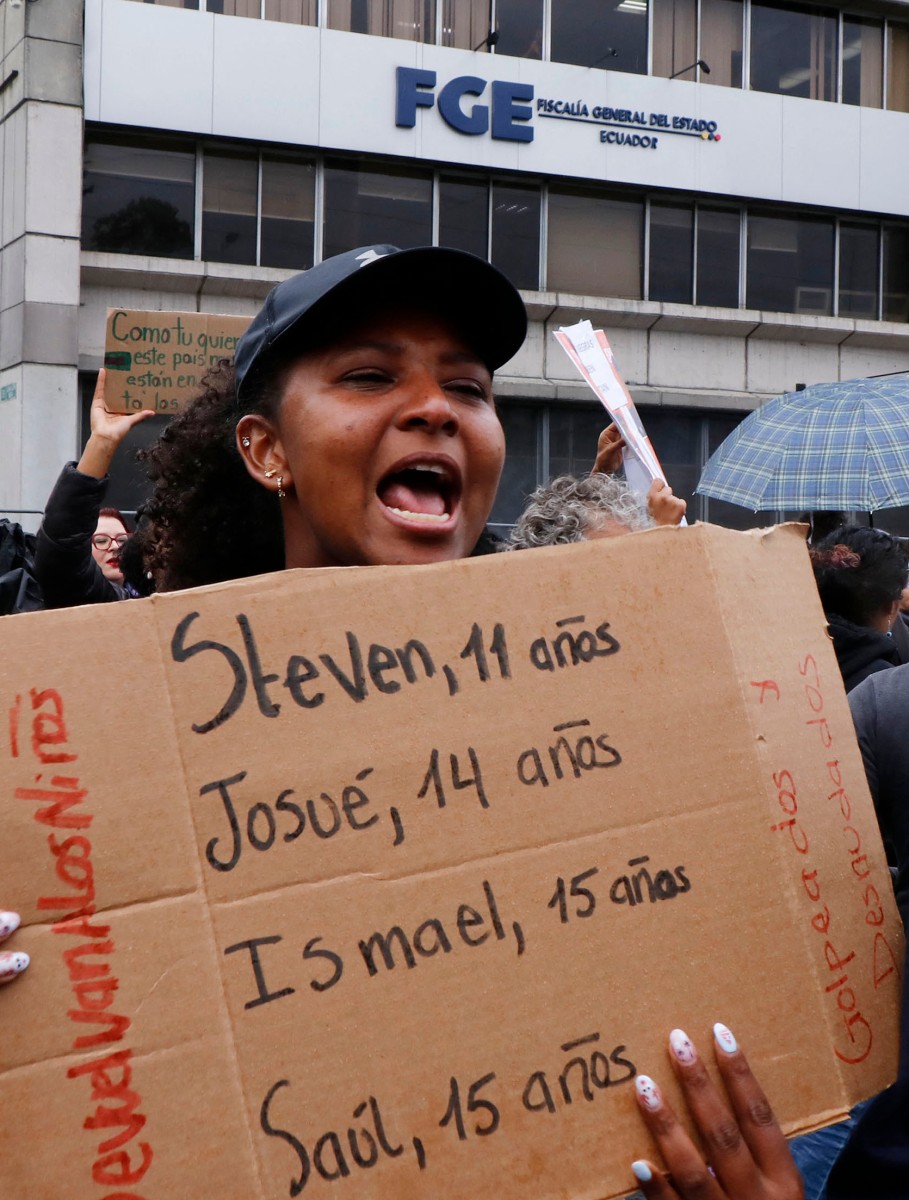 Mulher protesta no Equador para saber o paradeiro de uma criança e três adolescentes desaparecidos - GALO PAGUAY / AFP