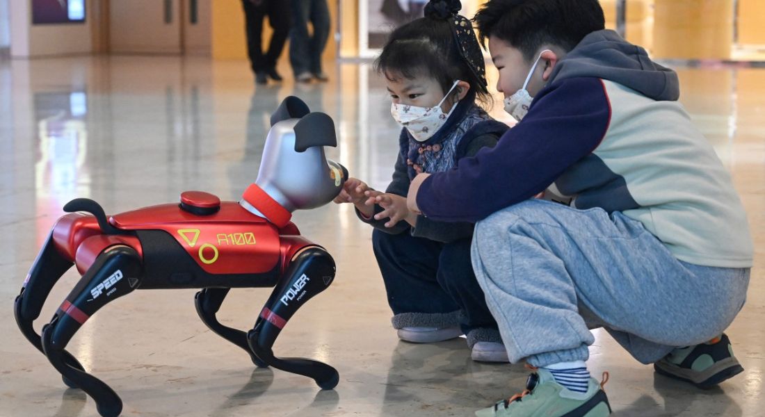 Crianças chinesas em loja de robôs interagindo com o Baby Alpha