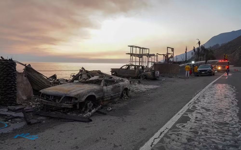 Carcaças de veículos consumidos pelo fogo se espalham ao longo da Pacific Coast Highway, em Malibu, Califórnia 