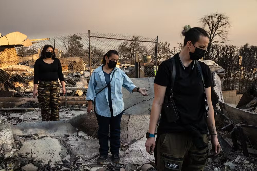 Famílias tentam reconhecer suas casas entre as ruínas carbonizadas no incêndio de Eaton, em Altadena, Califórnia 