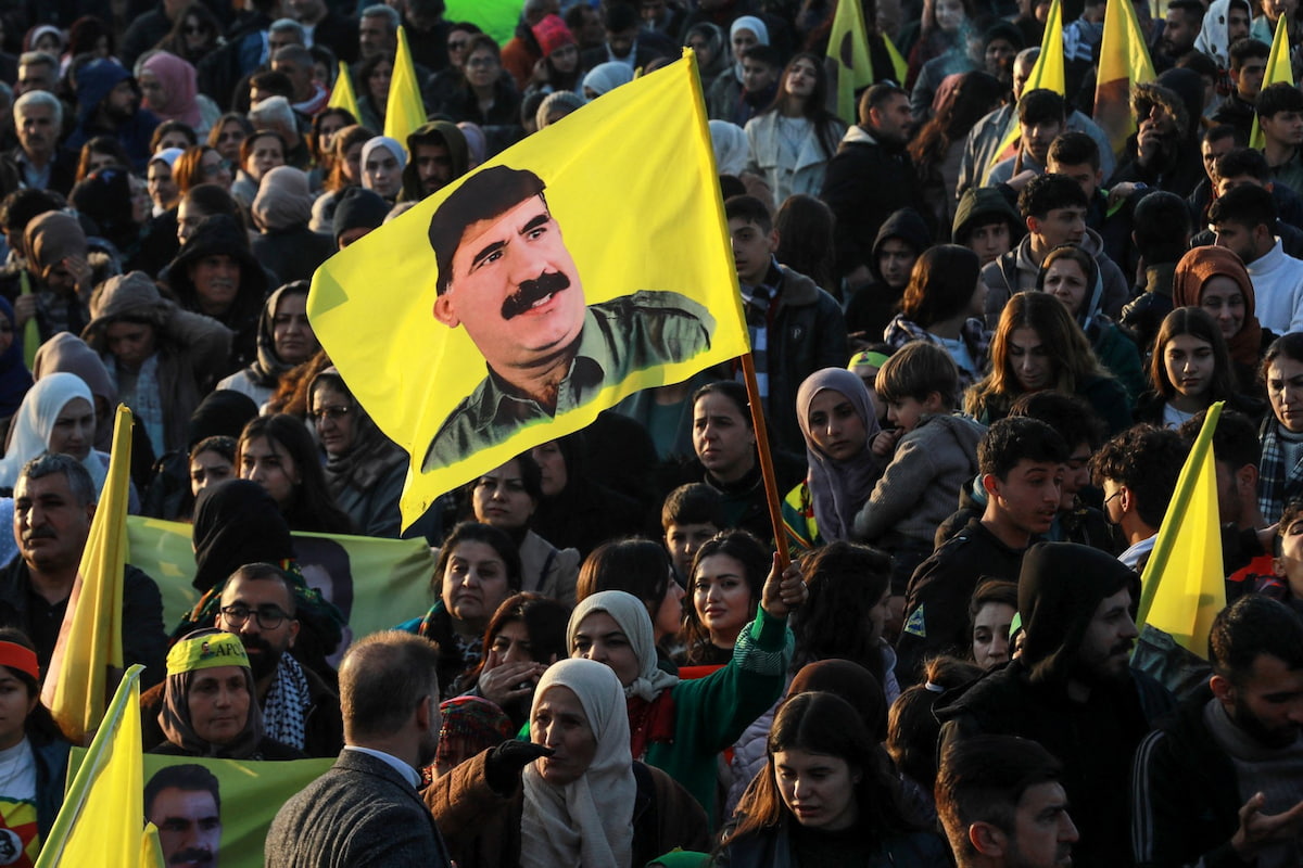 Uma mulher curda síria agita uma bandeira com a imagem do fundador do Partido dos Trabalhadores do Curdistão (PKK), Abdullah Ocalan