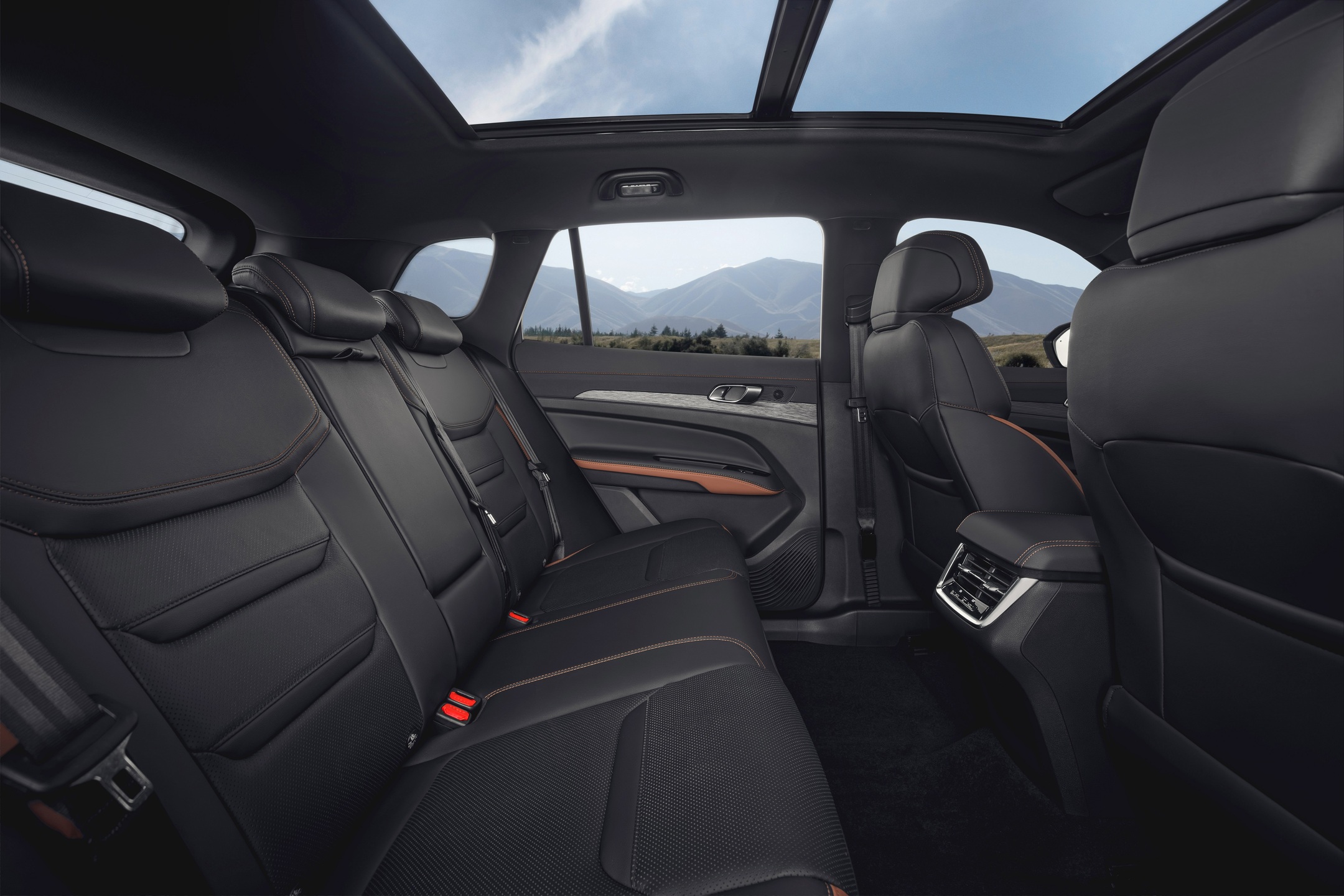 Três adultos viajam tranquilos na segunda fileira do Territory com folga para pernas e ombros.