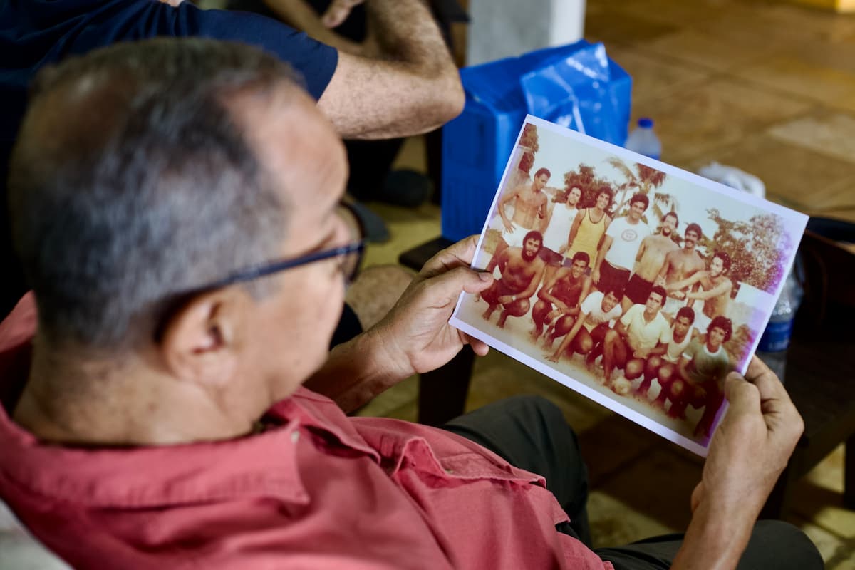 João Eudes observa foto de um dos times do Campeonato de Futebol de Praia de Olinda