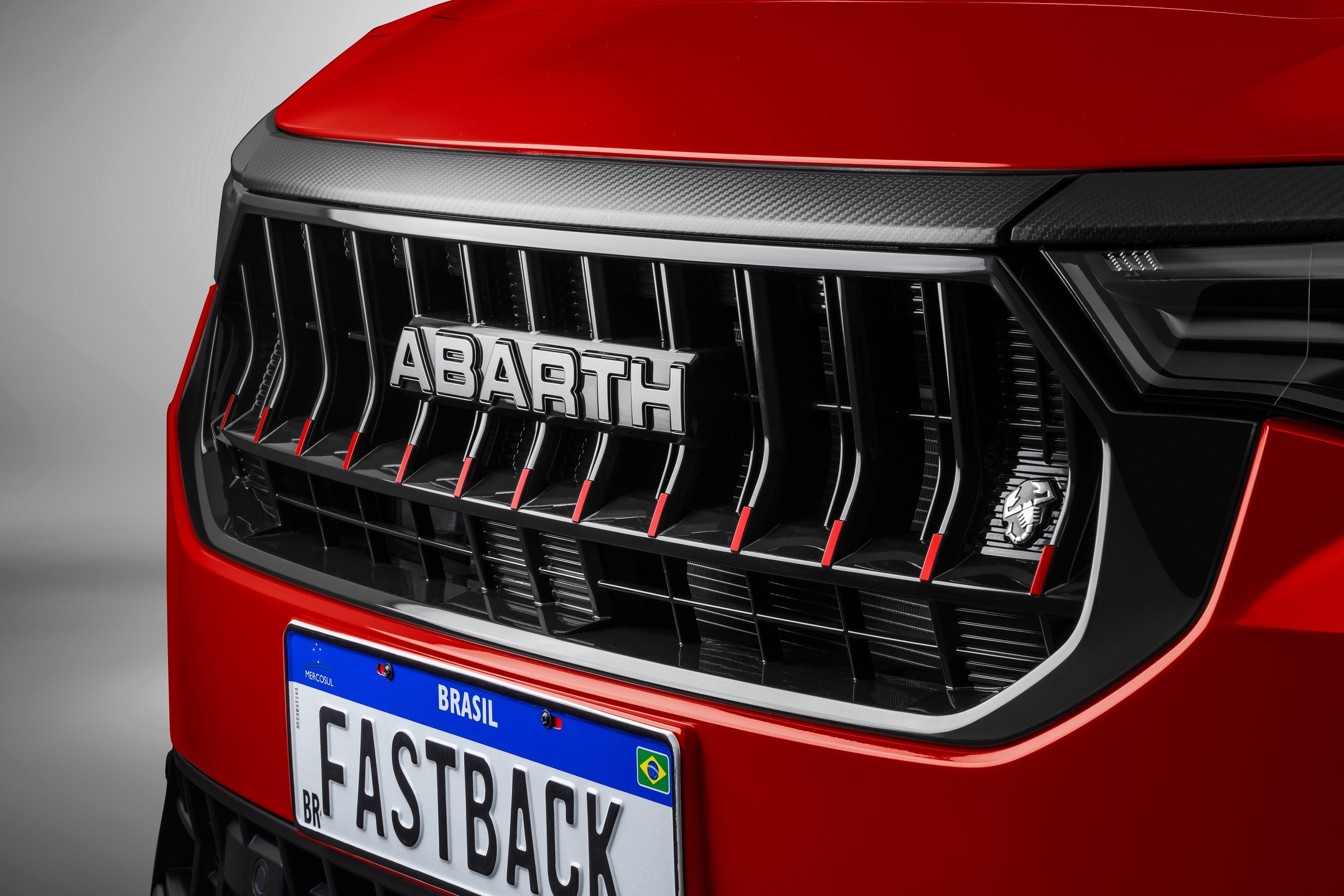 Nova grade preta com detalhes vermelhos reforça o visual agressivo e esportivo do Fastback Abarth 2026.