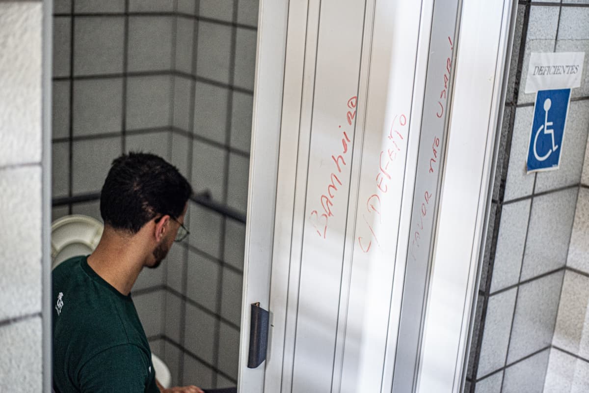 Estudante Heberth Santana em banheiro quebrado da UFPE